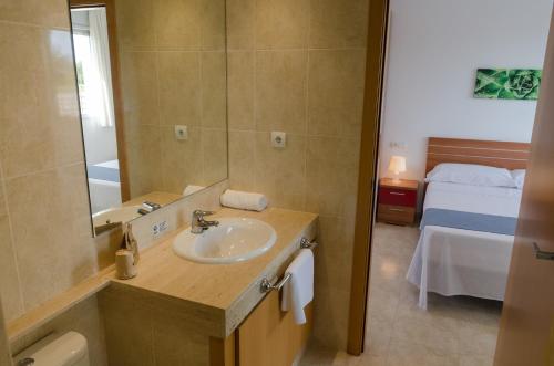 a bathroom with a sink and a mirror and a bed at Birds&Nature in L'Eucaliptus