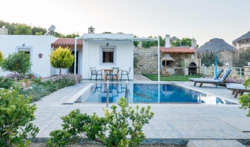 a villa with a swimming pool and a patio at Zeus's Daughtes Villas in Pitsidia