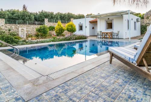 a swimming pool in the backyard of a house at Zeus's Daughtes Villas in Pitsidia