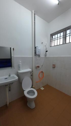 a bathroom with a toilet and a sink at Homestay Sri Pelangi Segamat in Segamat