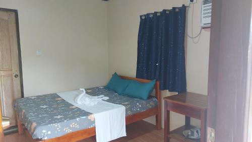 a small room with a bed and a table at Gardenview Homestay Siargao in General Luna