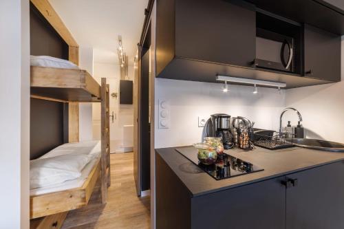 Il comprend une petite cuisine avec un évier et des lits superposés. dans l'établissement Studio l'Orée - City centre - Megève, à Megève