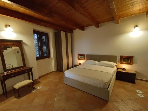 a bedroom with a large bed and a mirror at Il Rifugio in Casertavecchia