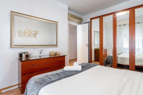 バレンシアにあるPrecioso piso moderno: Terraza, A/C, NetFlix, WiFiのベッドルーム1室(ベッド1台付)が備わります。壁に絵が飾られています。