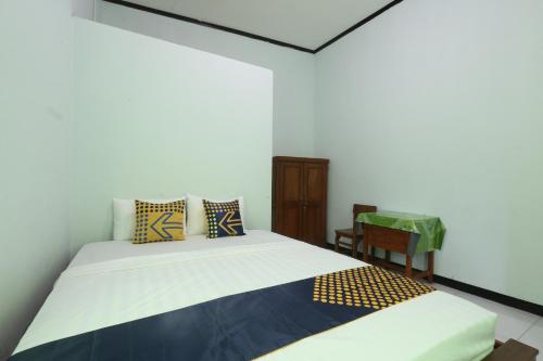 a bedroom with a bed and a chair at Homestay Almadina Syariah in Jepara