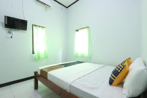 a bedroom with a bed and a flat screen tv at Homestay Almadina Syariah in Jepara