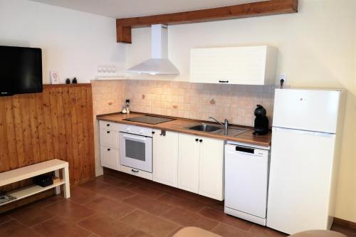 eine Küche mit einem weißen Kühlschrank und einer Spüle in der Unterkunft Apartma Andrej in Rateče
