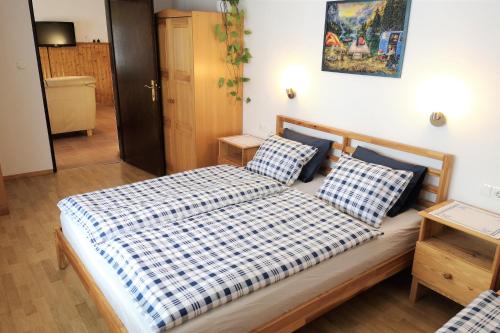Schlafzimmer mit einem Bett mit einer blau-weißen Bettdecke in der Unterkunft Apartma Andrej in Rateče