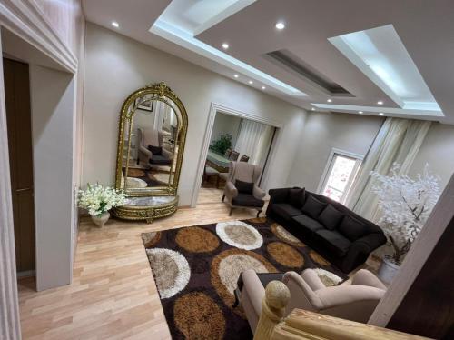 a living room with a black couch and a mirror at The best location in garden city in Cairo
