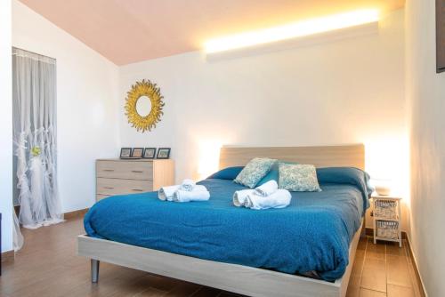 ein Schlafzimmer mit einem blauen Bett und Handtüchern darauf in der Unterkunft Piombino Apartments - Casa Roma in Piombino