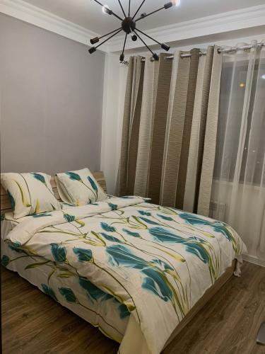 een slaapkamer met een bed met een kleurrijk dekbed bij студия Вефа in Bisjkek