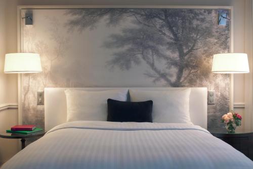 a bedroom with a large bed with two lamps at Renaissance Paris Nobel Tour Eiffel Hotel in Paris