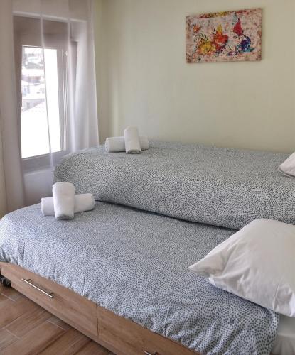 two twin beds in a room with a window at Zefyros in Samothraki
