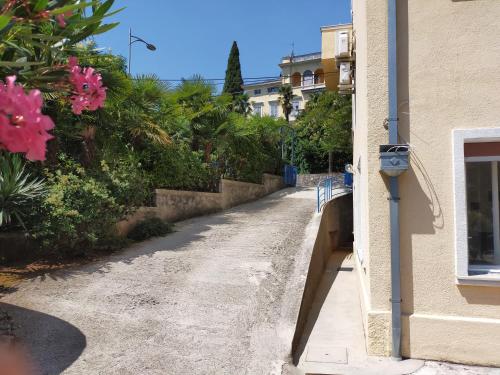 an empty street next to a building with pink flowers at Apartments Ivna Bilek in Opatija
