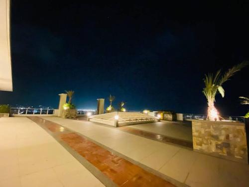 a night view of a building with palm trees at Modern Living by The Celandine DMCI in Balintawak in Manila