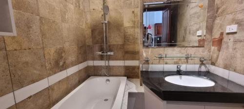 a bathroom with a sink and a bath tub at Ruby Serviced Apartment Liễu Giai in Hanoi