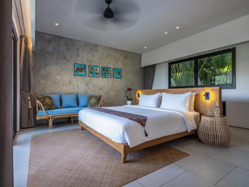 a bedroom with a large bed and a couch at Villa Pantai Indah - 100m to Pererenan Beach in Canggu