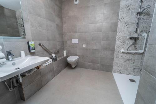 a bathroom with a sink and a shower and a toilet at Sure Hotel by Best Western Sarlat-la-Canéda in Sarlat-la-Canéda