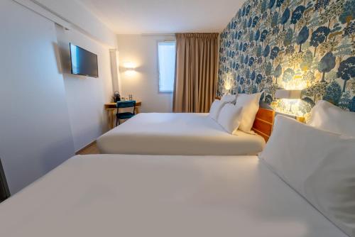 a hotel room with two beds and a tv at Sure Hotel by Best Western Sarlat-la-Canéda in Sarlat-la-Canéda