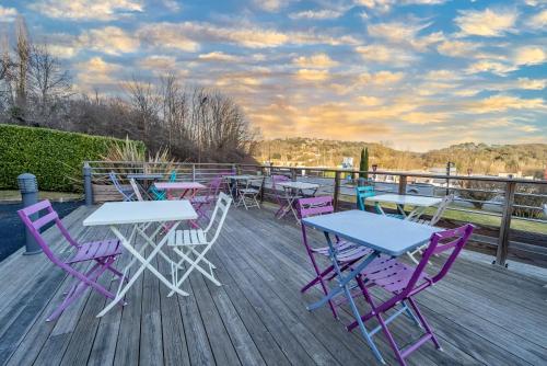 a group of tables and chairs on a deck at Sure Hotel by Best Western Sarlat-la-Canéda in Sarlat-la-Canéda