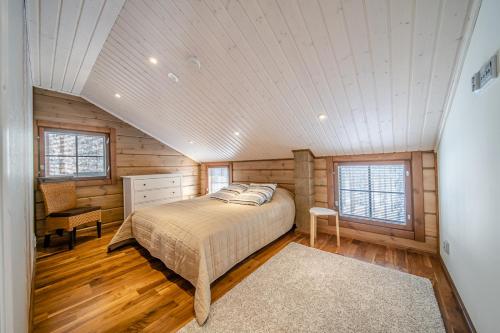 a bedroom with a bed in a room with wooden walls at Villa Amiraali Levi in Levi
