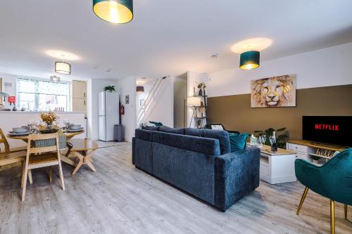 a living room with a blue couch and a kitchen at Spacious 3-Bed house in Chester by 53 Degrees Property, Ideal for Families & Professionals, FREE Parking - Sleeps 7 in Chester