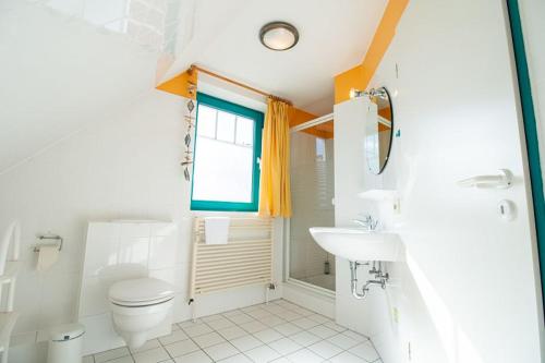 a white bathroom with a toilet and a sink at Ferienwohnung Seerose in Sellin