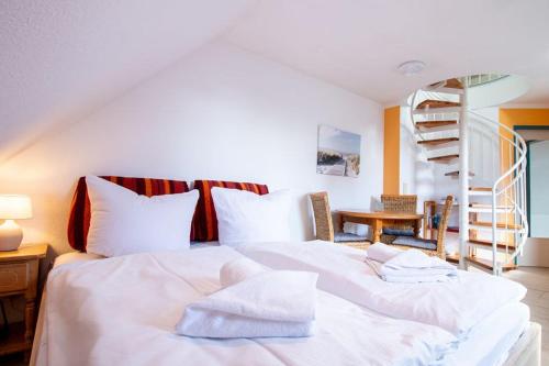 a bedroom with a bed with white sheets and a staircase at Ferienwohnung Seerose in Sellin