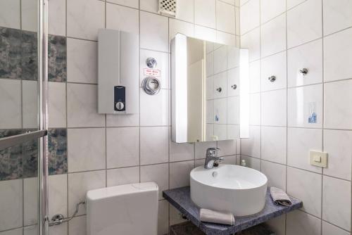 a bathroom with a sink and a toilet and a mirror at Schwarzwald Wölkchen in Baiersbronn