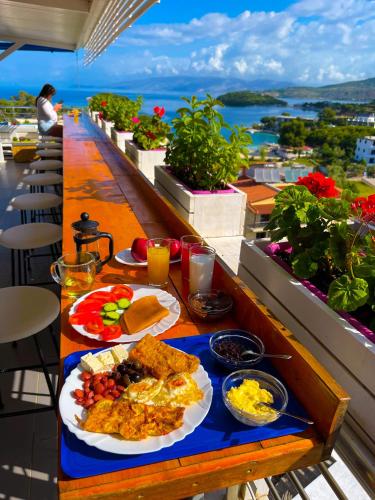 a table with a plate of food on a balcony at Hotel Ajden by Mira Mare in Ksamil