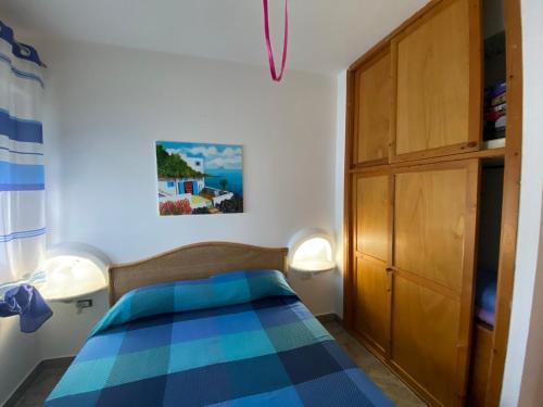 a bedroom with a bed and a wooden cabinet at Villa Heraclea sul mare in Trappeto