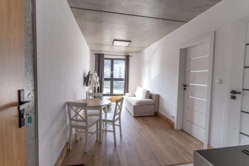 a kitchen and dining room with a table and chairs at Apartamenty Przystanek Morska in Gdynia