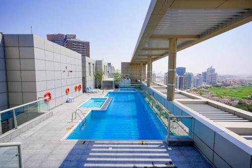 a swimming pool on the roof of a building at Alashrafia Saray 2BR apartment in Sport City in Dubai