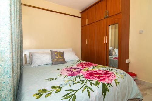 Un dormitorio con una cama con flores rosas. en Mt.Kenya View apartment, en Nanyuki