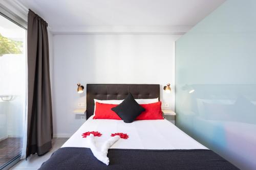 sypialnia z dużym łóżkiem z czerwonymi poduszkami w obiekcie Home2Book Design Studio Puerto de la Cruz w Puerto de la Cruz