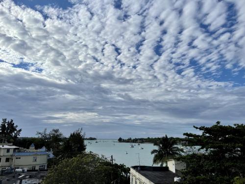 a cloudy sky over a body of water with boats at Studio H GrandBay Sea-View in Grand-Baie