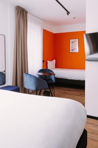 a hotel room with a bed and two chairs at ClapClap Hôtel, Food & Bar in Strasbourg