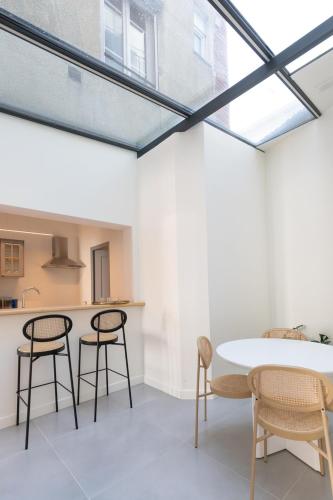 une pièce avec une table et des chaises et une cuisine dans l'établissement Appartement Porte mars, à Reims