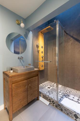 une salle de bain avec une douche avec un lavabo et un miroir dans l'établissement Appartement Porte mars, à Reims