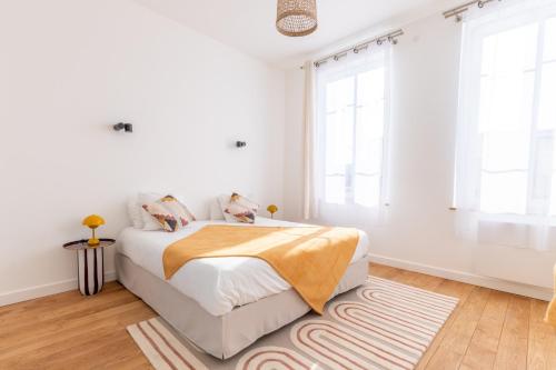 - une chambre blanche avec un lit et un tapis dans l'établissement Appartement Porte mars, à Reims