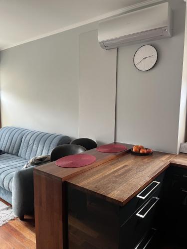 sala de estar con mesa y reloj en la pared en Urus Home Sopot en Sopot