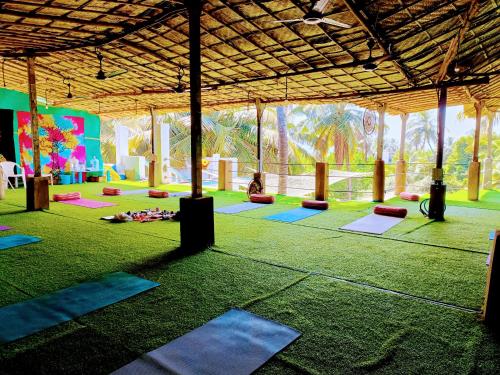 una habitación grande con muchas esterillas de yoga en Omkar wellness inn en Arambol
