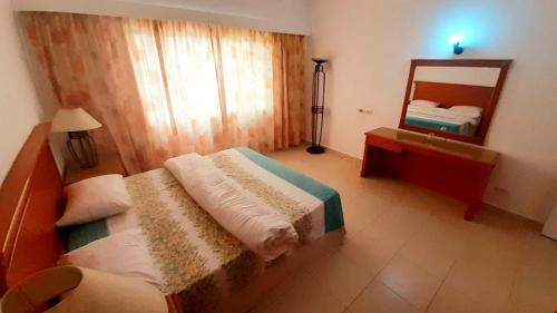 een hotelkamer met een bed en een spiegel bij Amwaj Oyoun hotel Nabq Bay in Sharm El Sheikh