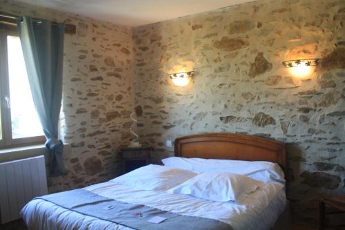 a bedroom with a bed and two lights on the wall at B&B Le Relais de Chantecor in La Coquille