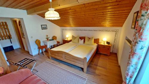 a bedroom with a large bed and a wooden ceiling at Gästehaus Fellner in Aschau im Chiemgau