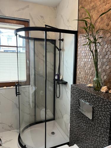 a shower with a glass enclosure in a bathroom at Urus Home Sopot in Sopot
