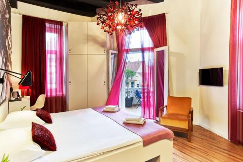 a bedroom with a large bed and a chandelier at Art Hotel Like in Zagreb