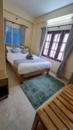 una camera con un grande letto e due finestre di Himalayan Hidden Treasure a Pokhara