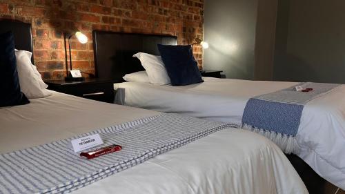 a hotel room with two beds with a thermometer on them at The Chameleon in Centurion
