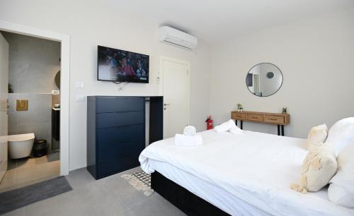 ein Schlafzimmer mit einem Bett und einem TV an der Wand in der Unterkunft וילה לארבל in Migdal